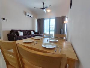 een woonkamer met een houten tafel en een bank bij Mykey Atlantis D-09-05 Melaka City in Melaka