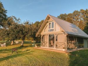 a small house with a gambrel roof on a lawn at Guest house Laimes taure in Vabole