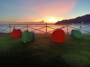 a group of three colored chairs in front of the water at Suhaila Palace in Perhentian Islands