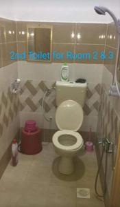 een badkamer met een toilet en een douchecabine bij Dusun Rimbun Agro Farmstay 2 in Kuala Kerai