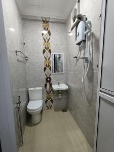 a small bathroom with a toilet and a sink at VILLA WANIE INN in Setiu