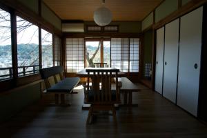 a dining room with a table and chairs and windows at えん吉野絶景広がる隠れ家1棟貸切ペットokサウナ室完備 in Yoshino