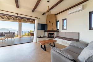 a living room with a couch and a fireplace at Alkis House by AegianKazarte in Kapótidhes