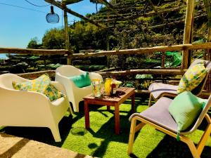 een groep stoelen en een tafel op een patio bij The Hidden Garden in Ravello