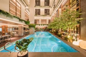 an indoor pool in a building with plants at Ashley Tanah Abang in Jakarta