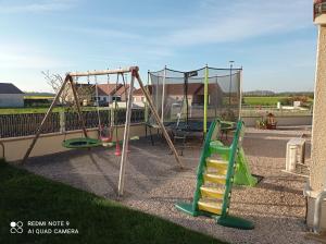 a playground with two swings and a slide at le clos des genêts in Agencourt