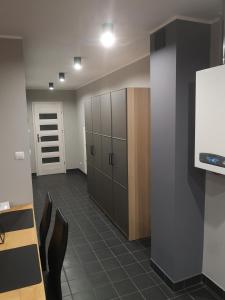 an office with a room with cabinets and a tv at Apartament exclusive Głuszyca in Głuszyca