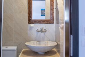 a bathroom with a bowl sink and a mirror at Alexandros by the Beach - Serifos in Livadakia