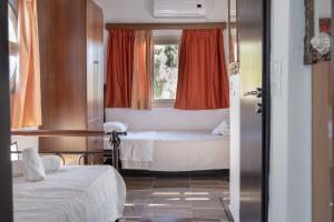 a bedroom with two beds and a window at Alexandros by the Beach - Serifos in Livadakia