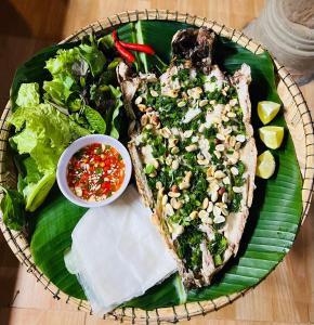 a plate of food with a sandwich and a salad at Jade Hotel in Phong Nha