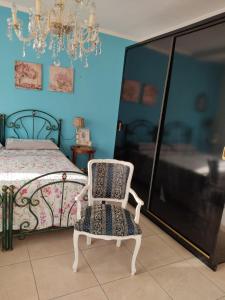 1 dormitorio con 1 cama con silla y lámpara de araña en Villa Lucia Anna, en Scalo dei Saraceni Manfredonia