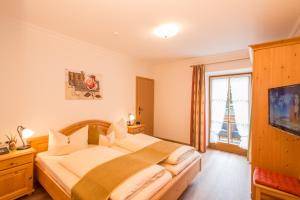 um quarto com uma cama grande e uma janela em Hotel Alpspitz B&B em Grainau