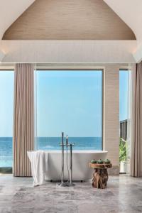 a bathroom with a tub with a view of the ocean at JOALI BEING in Raa Atoll