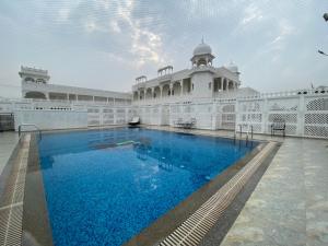 a building with a swimming pool in front of it at Dowlat Villas Palace-The Heritage in Himatnagar