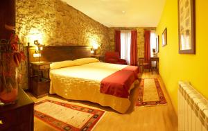 a bedroom with a bed and a stone wall at Don Pedro in Avilés