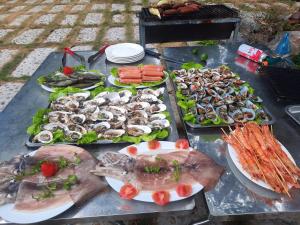 a table with different types of seafood and vegetables at Tran Chau Garden Home in Cat Ba