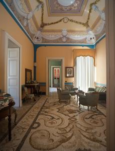 una sala de estar con techo artesonado y una habitación con sofá en Palazzo Francesco Grassi, en Aradeo
