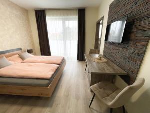Televízia a/alebo spoločenská miestnosť v ubytovaní Apartmány Katalin