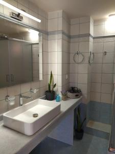 ein Badezimmer mit einem weißen Waschbecken und einem Spiegel in der Unterkunft Villa Serenity in Vóvikes