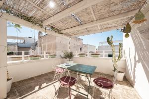 a patio with a table and chairs on a balcony at Casa Chiasso Cacace in Monopoli