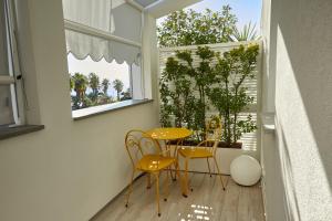 un piccolo balcone con tavolo e sedie gialli di Attico Fronte Mare Residenza Matilde a Chiavari