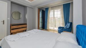 a bedroom with a bed and a chair and a window at Blue - 4 Bedroom Holiday Villa in Hisarönü in Oludeniz +55 photos