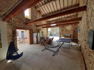 La maison SPA, PISCINE et CLIMATISATION في Sainte-Valière: غرفة مع طاولة بينج بونغ في مبنى حجري