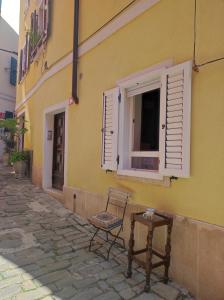 Ein Stuhl und ein Tisch stehen vor einem Gebäude in der Unterkunft Apartment Mazza in Piran