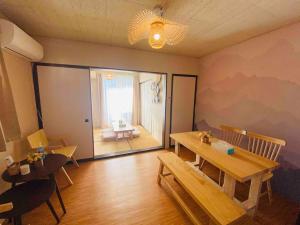 Habitación con mesa, sillas y ventana en 和モダンなお部屋 箱根神社参拝や駅伝観戦箱根観光に最適な芦ノ湖鳥居が見える海賊船コンビニ徒歩圏201 en Hakone