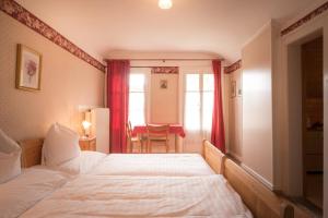 ein Hotelzimmer mit einem Bett und einem Tisch in einem Zimmer in der Unterkunft Historic Hotel Falken in Wengen