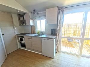 a kitchen with white cabinets and a large window at Casa Azul-Tiny house with fantastic view, big outdoor space and pool in Silves