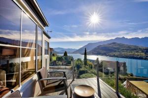 a balcony with a view of the water and mountains at Unbeatable Panoramic Lake & Mountain & Garden Views in Queenstown
