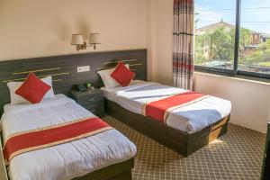 a hotel room with two beds and a window at Mirage Inn in Lumbini