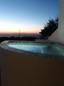a swimming pool with a sunset in the background at Kiklamino Sunset Studios in Oia