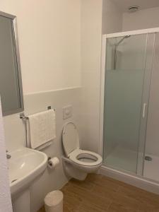 La salle de bains est pourvue de toilettes, d'un lavabo et d'une douche. dans l'établissement My KB Hôtel Montélimar, à Saulce-sur-Rhône