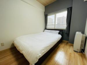 Säng eller sängar i ett rum på サービスアパ―トメントＳＡＰＰＲＯ札幌ステーション5