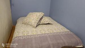 - un petit lit avec un oreiller dans l'établissement SAWADDEE, à Clermont-Ferrand