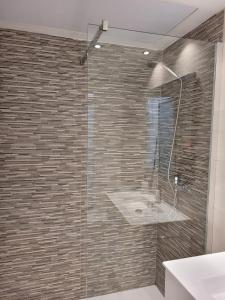 a bathroom with a glass shower with a sink at Beautiful, modern apartment in sunny Corralejo in Corralejo