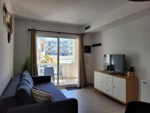a living room with a blue couch and a tv at Beautiful, modern apartment in sunny Corralejo in Corralejo