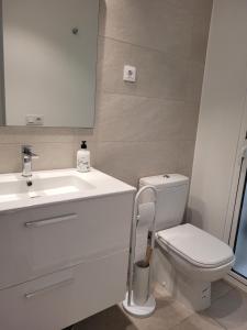 科拉雷侯的住宿－Beautiful, modern apartment in sunny Corralejo，浴室配有白色卫生间和盥洗盆。