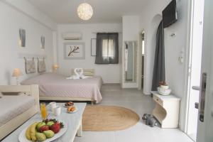 a room with two beds and a table with fruit on it at Diplos Studios in Parikia