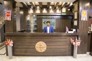 a man standing behind a bar in a restaurant at Mirage Inn in Lumbini