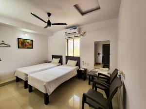 a bedroom with two beds and a table and chairs at Shivani Inn Hotel & Banquet in Seonī