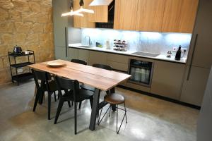 eine Küche mit einem Holztisch und Stühlen in der Unterkunft NUMRU 27 Expertly restored small house of character in Cospicua