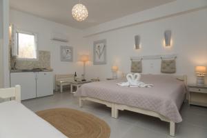 a white bedroom with a bed with a towel on it at Diplos Studios in Parikia