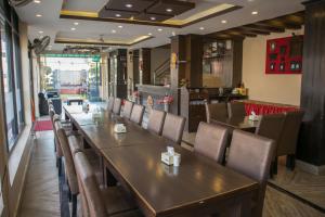 a dining room with wooden tables and chairs at Mirage Inn in Lumbini