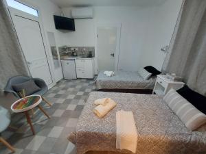 une petite chambre avec 3 lits et une cuisine dans l'établissement Magdalene's City House Inn, à Larnaka