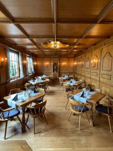 Hotel Württemberger Hof في ريوتلنغن: غرفة طعام مع طاولات وكراسي خشبية