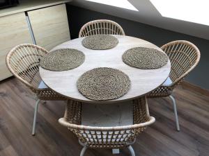 una mesa blanca con cuatro sillas alrededor en Precioso apartamento con vistas al mar en Carnota en Carnota