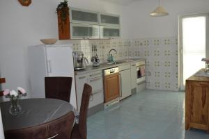a kitchen with white appliances and a table in it at Kampor 211 in Kampor +15 photos